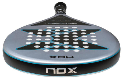 A close-up of the NOX AT10 Genius Ultralight By Augustin Tapia 2025 padel racket shows its round, dark gray face with a bold “X” design, small holes, “NOX” branding on the frame and handle, and an advanced HR2 core.