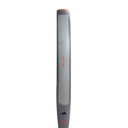 A close-up shows the adidas ADIDAS Drive Grey 3.4 Padel Racket, featuring a textured grip, subtle dot pattern, and orange-black accents, displayed vertically on a white background.
