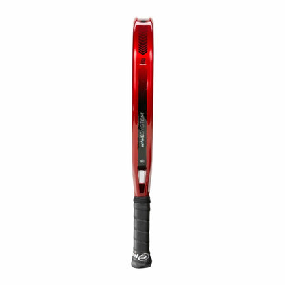 The Bullpadel Xplo Comfort 2025 padel racket, shown from the side, features a red design with a black grip and slim profile. The "WAVESTEEL" text is visible on the shaft, emphasizing its explosive power against a plain white background.
