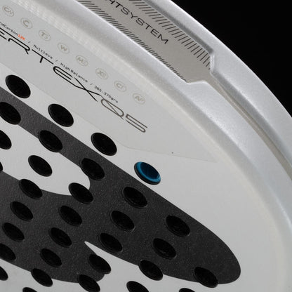 Close-up of the Bullpadel Pearl 2026 Padel Racket, a lightweight racket by Bullpadel with a perforated surface, blue grommet, textured black grip zones, and technical prints—designed to reduce arm fatigue during play.