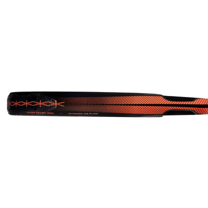 Close-up of the adidas ADIDAS Cross It CTRL Padel Racket, showcasing its black and red design with diagonal orange stripes and geometric details, featuring the text “Extra Boost Grip” and “Dynamic Air Flow.”.