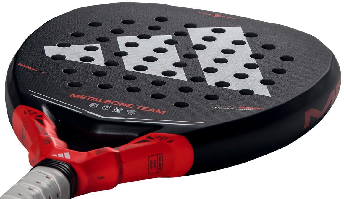 A close-up of the adidas Metalbone Team 2026 Padel Racket, an advanced padel racket with Spin Blade Gritt technology, perforated black face, white adidas branding, and red accents near the handle.