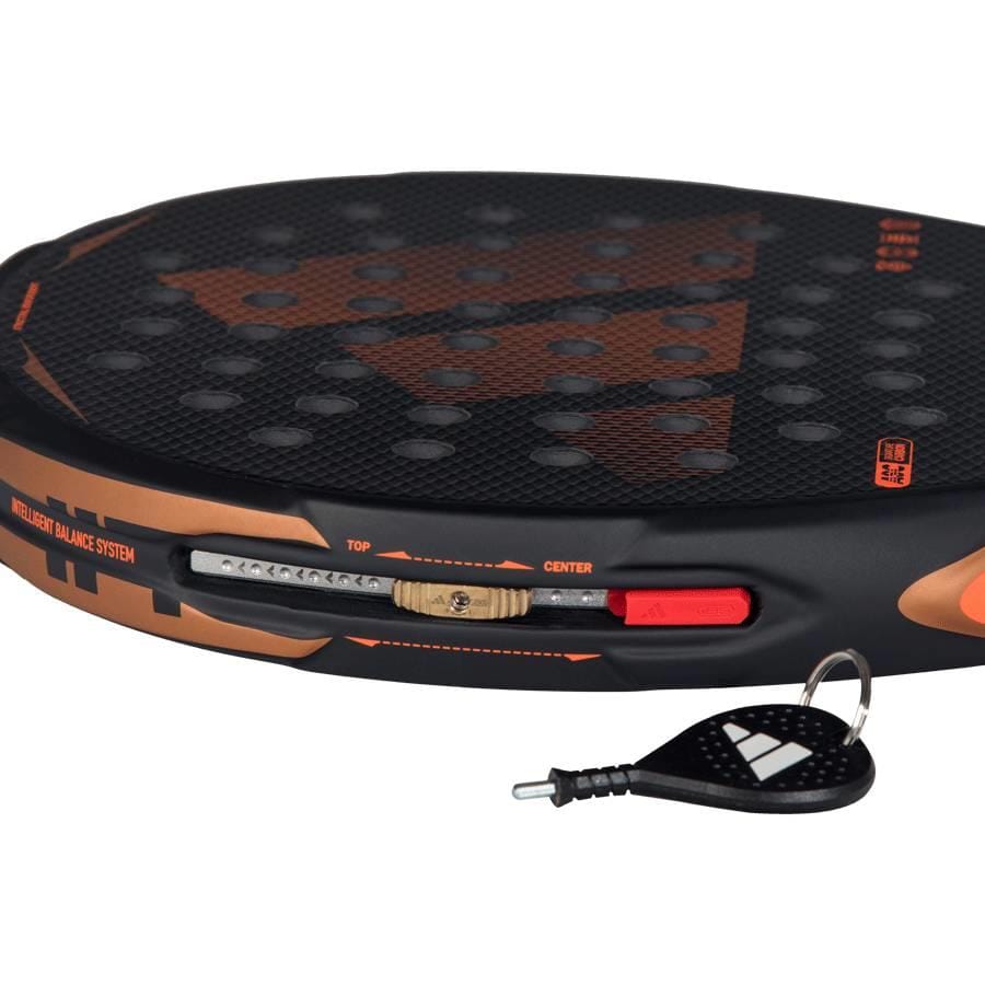 Close-up of the adidas Arrow Hit CTRL 2026 Padel Racket with an intelligent balance system, featuring a sliding mechanism and an adjustment key shown in the foreground.