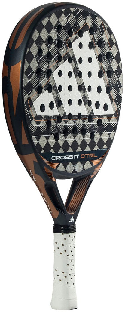 A close-up of the adidas Cross It Ctrl 2026 Padel Racket, featuring a black, brown, and white geometric design on carbon fibre, Spin Blade Mould texture, perforated face, and a white grip handle.