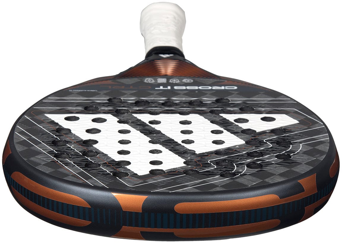 A close-up of the adidas Cross It Ctrl 2026 Padel Racket, a carbon fibre padel racket in black, white, and copper with visible holes, a white grip, and Spin Blade Mould technology.