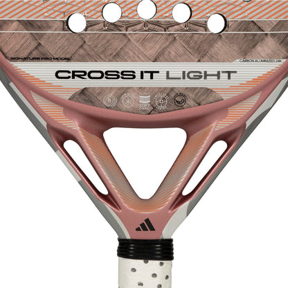 Close-up of the adidas Cross It Light 2026 Padel Racket’s center, showing its carbon fiber woven texture, ventilation holes, and white perforated grip. The adidas logo is visible near the handle.