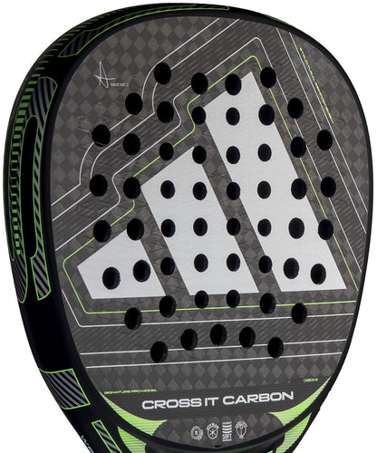 Close-up of the adidas Cross It Carbon 2026 Padel Racket, an advanced carbon fibre racket with green accents, circular holes, and a bold white adidas logo on its sleek black surface.