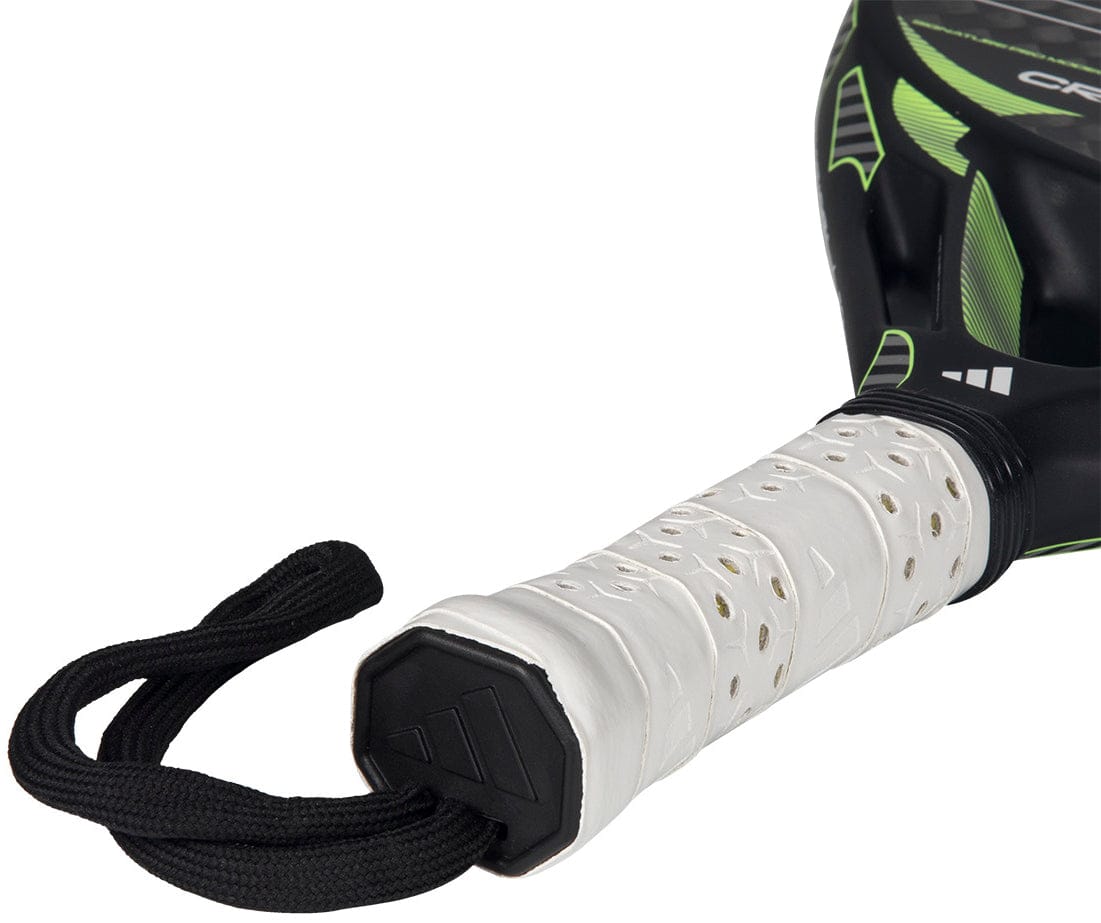 Close-up of the adidas Cross It Carbon 2026 Padel Racket handle, showing its white perforated grip and black wrist strap. The advanced carbon fibre racket displays bold black and green accents near the top.