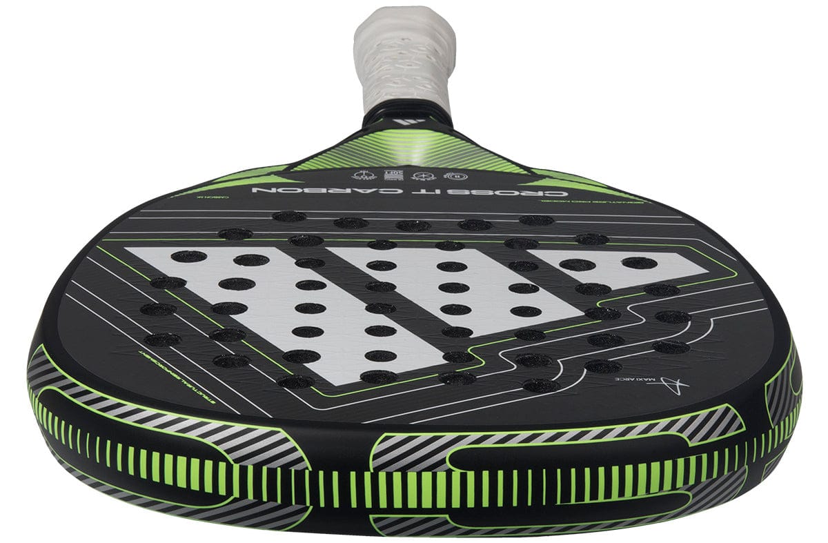 A close-up of the adidas Cross It Carbon 2026 Padel Racket shows its advanced carbon fibre construction, perforated face, and white grip handle, captured from the handle looking toward the rounded head.