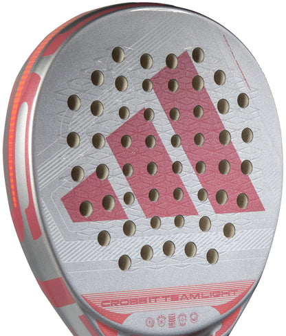Close-up of the lightweight adidas Cross It Team Light 2026 Padel Racket in silver and red, showing a round hole pattern forming the adidas logo and an Extra Power Grip on the hitting surface.