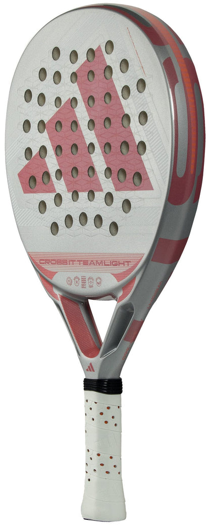The adidas Cross It Team Light 2026 Padel Racket features a white and pink design, textured surface, round holes, Extra Power Grip, plus a white handle with red dots and the bold adidas logo on the face.
