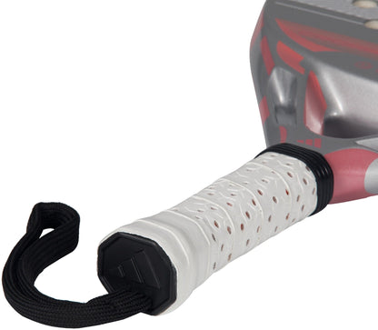 Close-up of an adidas Cross It Team Light 2026 Padel Racket handle with a perforated white Extra Power Grip and black wrist strap. The lightweight racket boasts a striking red and silver frame.