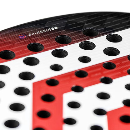 Close-up of the Tecnifibre Curva Speed Padel Racket by Tecnifibre, showcasing a red and white geometric face with black holes and "SPINSKIN 3D" on its 16k carbon surface.