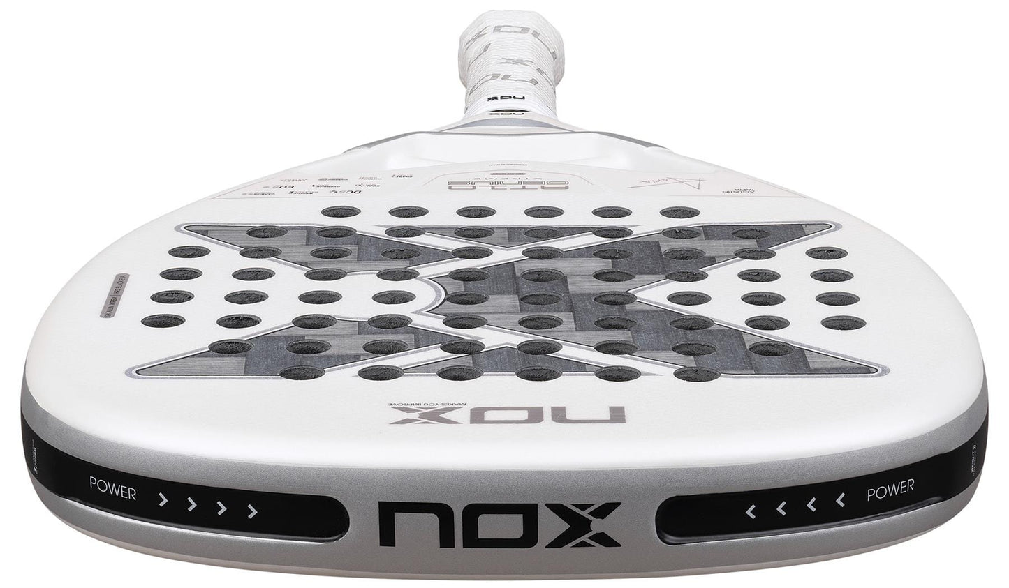 A close-up of the NOX AT10 Genius Attack 12K Alum Extrem By Agustín Tapia 2026 Padel Racket, showing its perforated surface, bold NOX branding on the lower edge, and “POWER” text on both sides of the rim for ultimate power play.