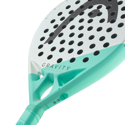 Close-up of the HEAD Gravity Motion 2024 Padel Racket featuring Auxetic 2.0 technology, with a primarily white design, black dots, light teal accents, and “GRAVITY” branding near the center. Brand Name: HEAD.