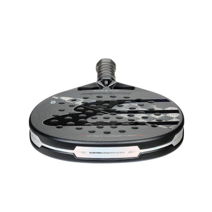 A close-up of the Bullpadel HACK 04 Hybrid 2026 Padel Racket shows its perforated surface, textured grip, sleek design, and Total Channel technology on the face.