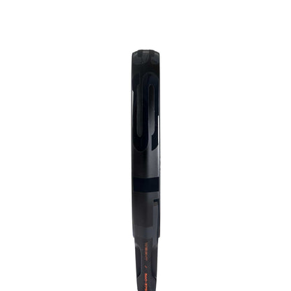 Close-up of the adidas ADIDAS Cross It 3.4 Padel Racket's black Carbon 15K face edge against a white background, showcasing design details and string holes—ideal for aggressive players who demand precision.