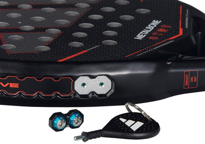 Close-up of the adidas Metalbone by Ale Galán 2026 Padel Racket, showing the "METALBONE" label, weight and balance system with two hexagonal weights, adjustment screws, and a small black adidas key tool with keyring nearby.