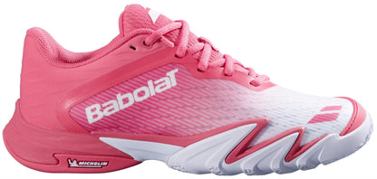 The Babolat Premura 3 Women's Padel Shoes in Sun Kissed Coral feature a pink and white design with pink laces, a white sole displaying the Michelin logo, and the Babolat logo near the heel and toe.