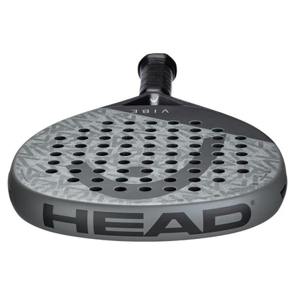 A close-up of the HEAD Vibe 2025 Grey / Black Padel Racket, showcasing its teardrop-shaped perforated grey face, black handle, and "VIBE" branding on the neck.