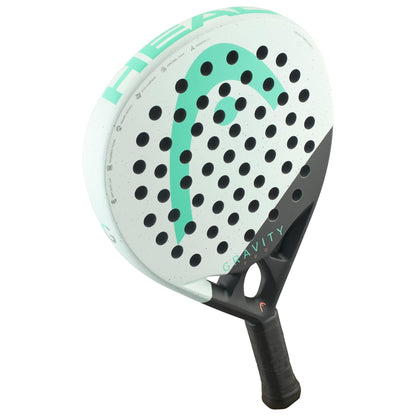 The HEAD Gravity Pro 2024 Padel Racket features a white and black design with a green logo, "GRAVITY" on the face, a perforated aerodynamic structure, and Auxetic 2.0 technology for superior feel.