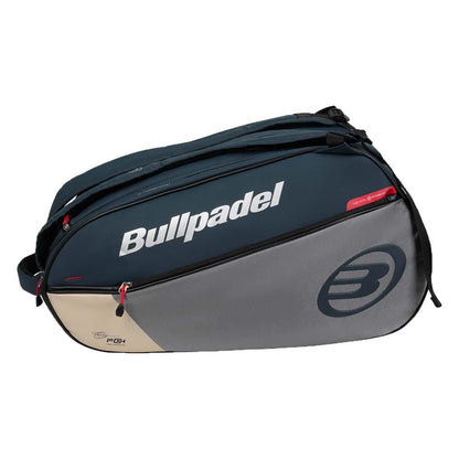 Carry your padel gear like Fede Chingotto with the Bullpadel BPP26017 Neuron Padel Racket Bag in grey, featuring multiple zippered compartments, a shoulder strap, and bold Bullpadel branding.