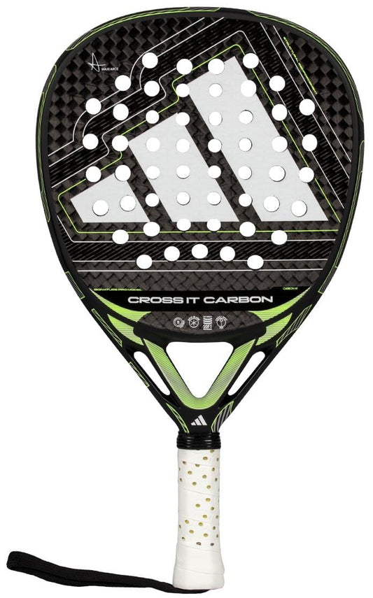 The adidas Cross It Carbon 2026 Padel Racket features a black and green design with a triangular logo, white perforated face, carbon fiber texture, gold-dotted white grip, and black wrist strap for advanced-level play.