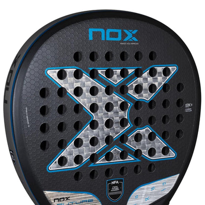 Close-up of the NOX NFA Future Hybrid 12K Alum Padel Racket by NOX, featuring a bold silver and blue "X," circular perforations, and branding—highlighting this modern padel racket’s style and versatile performance.