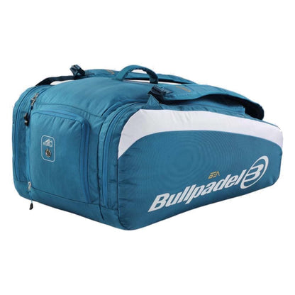 The Bullpadel BPP26021 Pearl Padel Racket Bag in blue features a spacious main compartment, side zipper pocket, carrying handles, a shoulder strap, and a bold Bullpadel logo on the side.