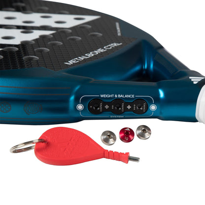 Close-up of the adidas Metalbone CTRL 3.3 Padel Racket, designed for advanced players, featuring an adjustable weight and balance system with three removable weights and a red key tool shown.