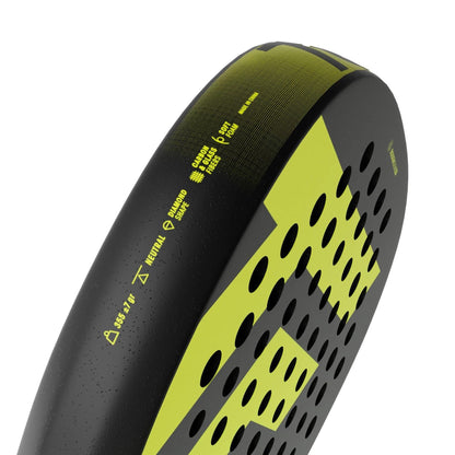 Close-up of the edge of the Tecnifibre Bomba Soft Padel Racket by Tecnifibre, highlighting perforated holes and technical details on its black and yellow fibreglass frame designed for comfort.