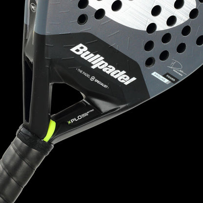 Close-up of a black Bullpadel XPLO Comfort 2026 Padel Racket with perforated holes, a black grip, and branding on the frame, featuring "Bullpadel" and "X-PL" near the handle for exceptional comfort.