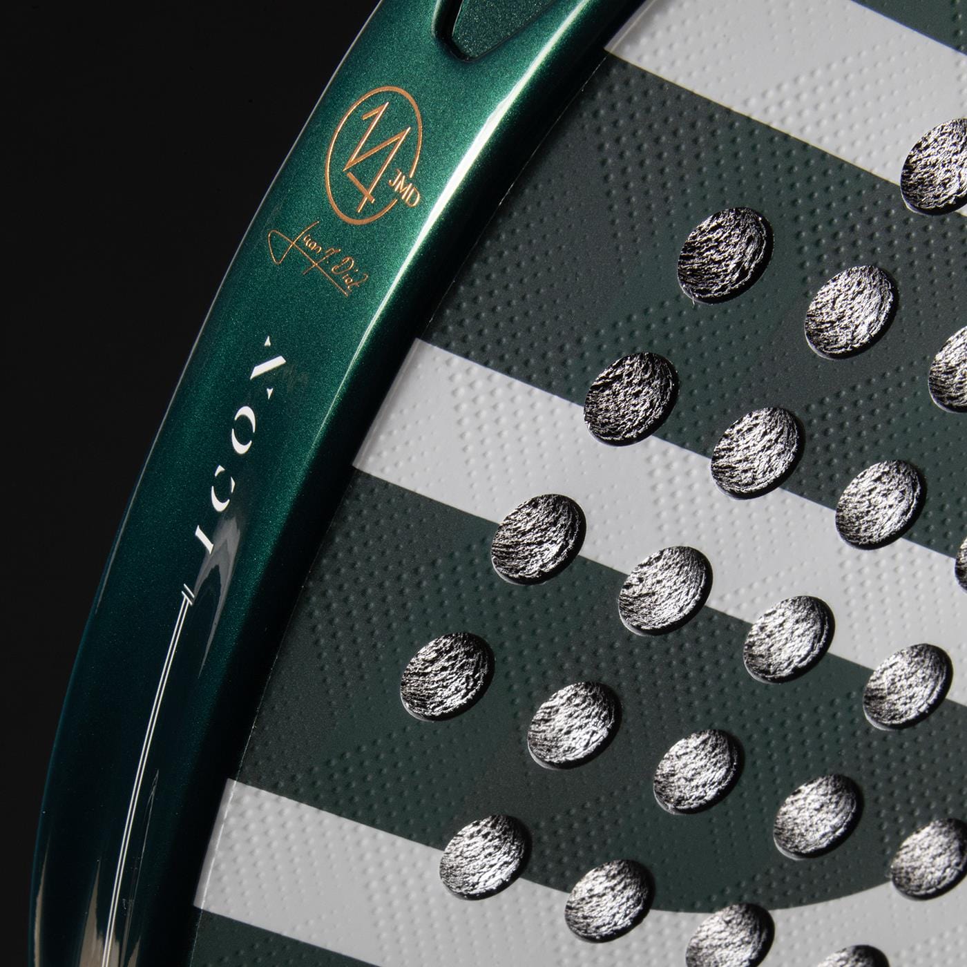 Close-up of the Bullpadel Icon 2026 Padel Racket face, featuring textured circular perforations, Juan Martín Díaz's signature details, and a bold "14" marking near the edge against a dark background.