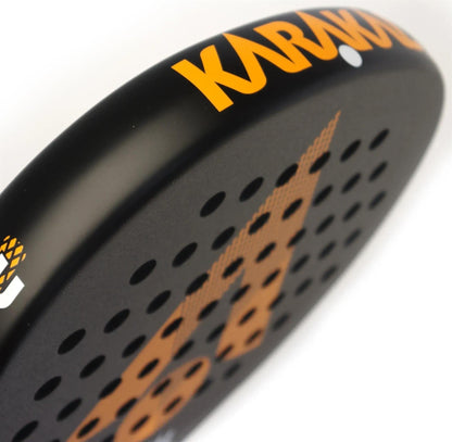 Close-up of the lightweight Karakal Air Lite 345 Orange Padel Racket, black with orange "Karakal" branding and graphics, featuring multiple small holes on its surface.