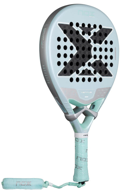 The NOX Luxury Ventus 12K Hybrid Lite 2026 Padel Racket features a light blue design with a large black "X," perforated 12K carbon fibre face, and matching grip and wrist strap. The model name "Ventus" is visible on the front.