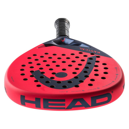 A close-up of the HEAD Radical Elite 2024 padel racket shows its teardrop shape, red and black design, Auxetic technology, perforated face, large HEAD logo, and black grip handle.
