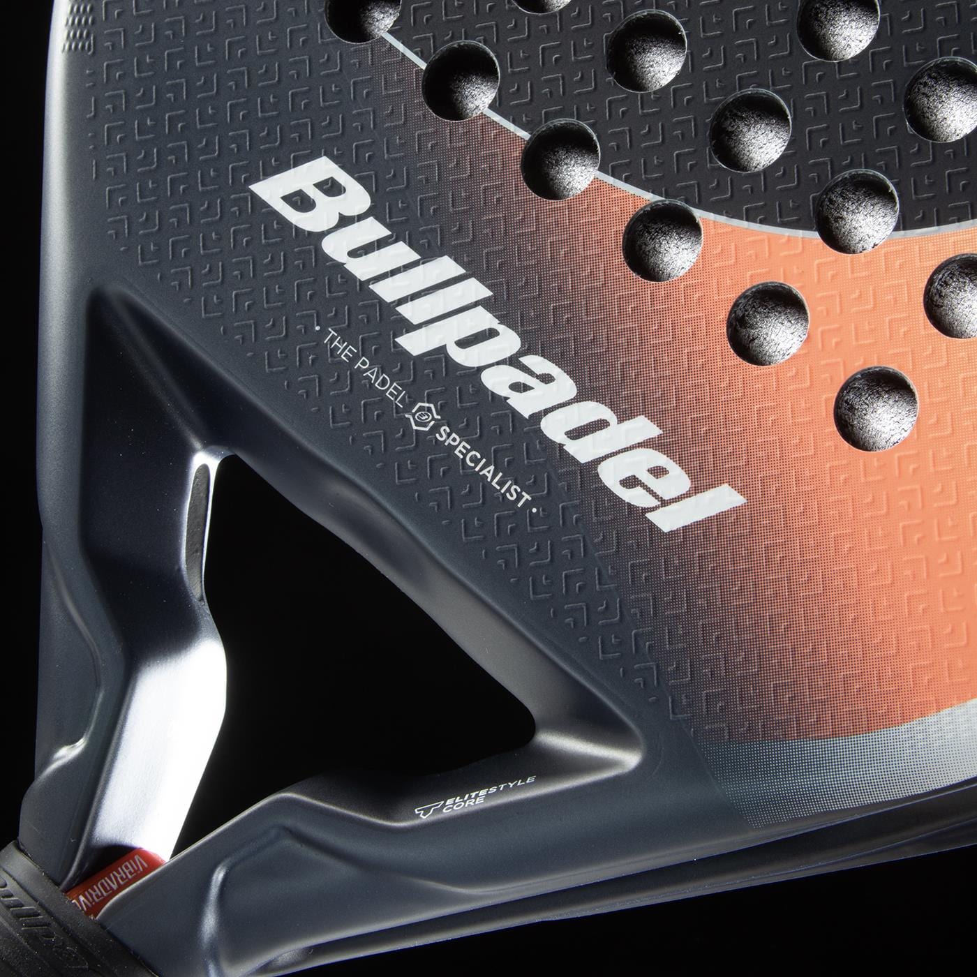 Close-up of the Bullpadel Elite W 2026 Padel Racket, a lightweight racket with the Bullpadel brand, textured surface with circular holes, and a stylish black and orange pattern.
