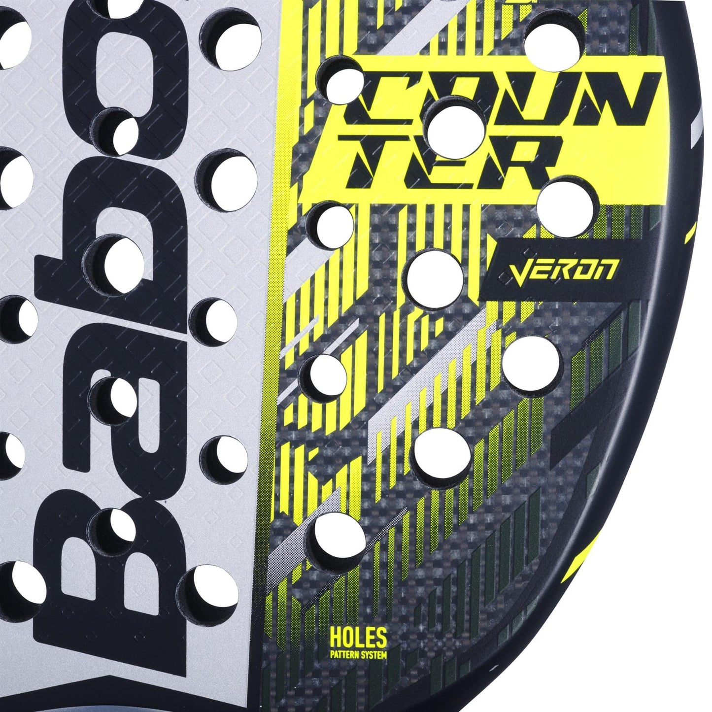 Close-up of the Babolat Counter Veron 2.5 Padel Racket, showing "COUNTER" and "VERON" in yellow, black, and gray with geometric patterns, circular holes, the Babolat logo on the left, and featuring Carbon Flex technology.