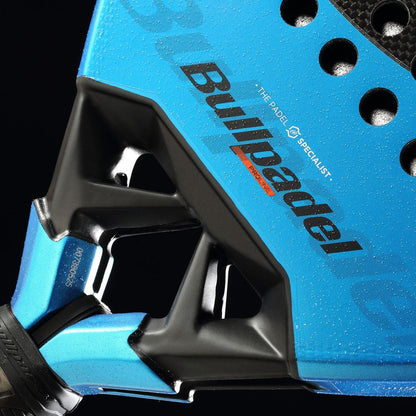 Close-up of the Bullpadel Vertex 05 GEO 2026 padel racket highlighting its blue color, brand logo, distinctive triangular frame design, and water droplets on its high-performance surface.