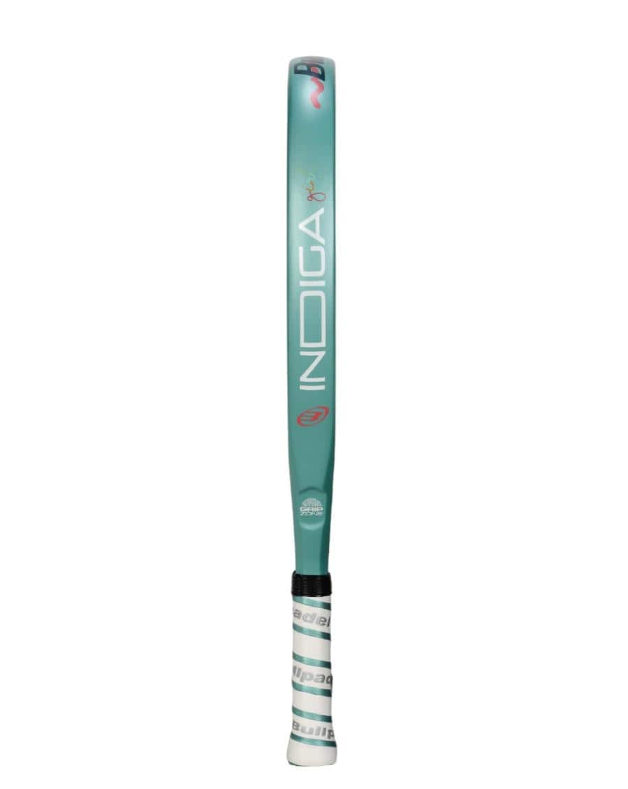 The Bullpadel Indiga Junior 25 Girls Padel Racket by Bullpadel features a light blue-gray design with "INDIGA" in white and a black-white grip—ideal for young players seeking a quality junior padel racket.