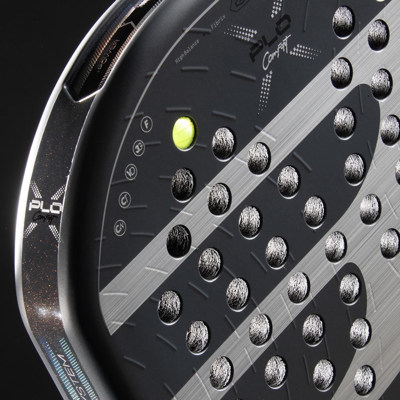 Close-up of the Bullpadel XPLO Comfort 2026 Padel Racket by Bullpadel, featuring silver circular holes, a neon yellow padel ball partially visible, and a sleek textured design—engineered for comfort and power on the court.