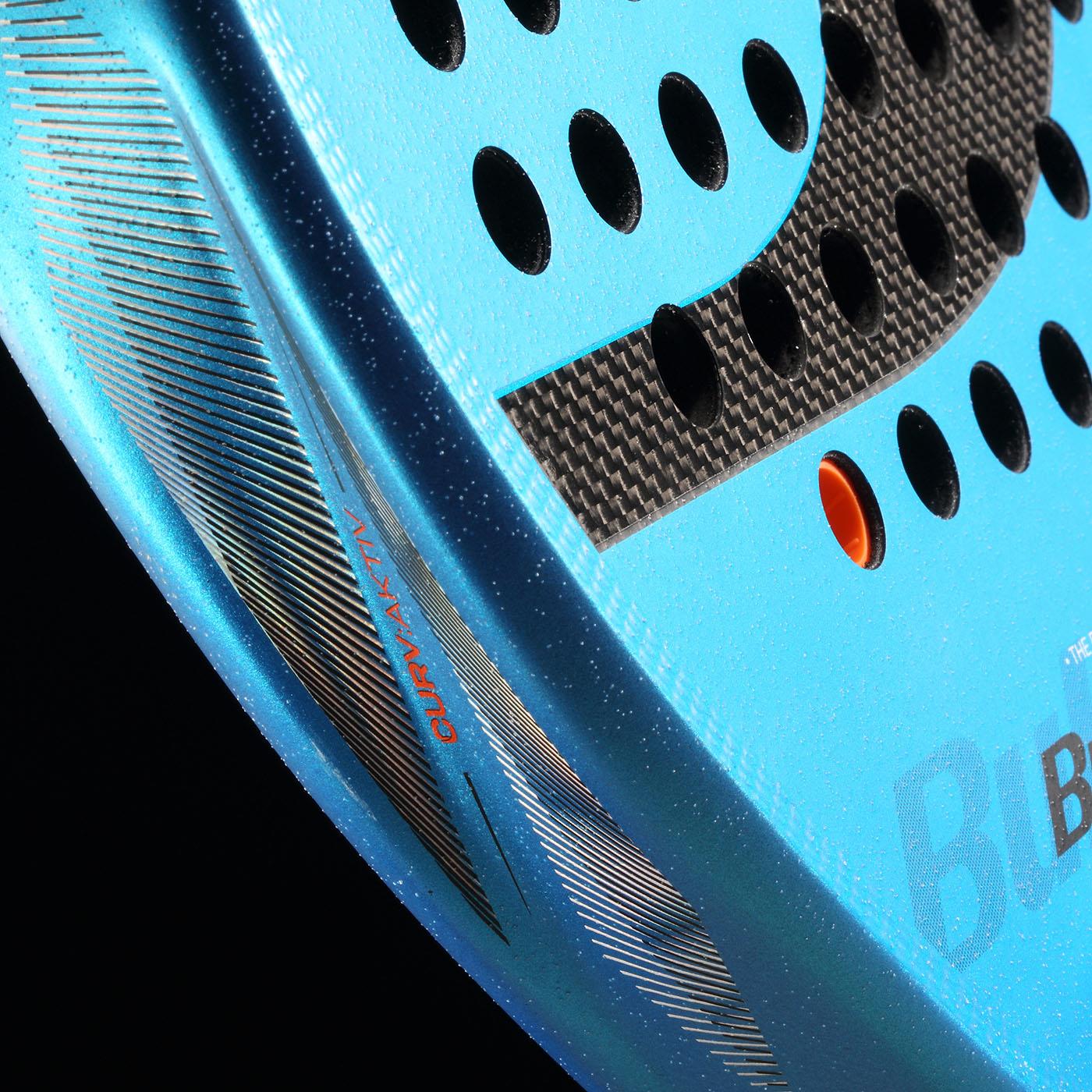 Close-up of the Bullpadel Vertex 05 W 2026 Padel Racket, highlighting its textured surface, black perforations, carbon fiber accents, orange detail near the edge, and "CURVAKTIV" branding on the rim.