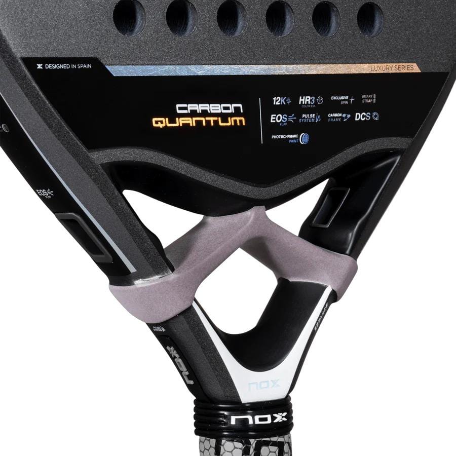 Close-up of the NOX Luxury Quantum 12K Carbon 2025 Padel Racket, highlighting EXCLUSIVE SPIN technology and technical specs on its black 12K carbon fiber surface, with focus on the handle and throat area.