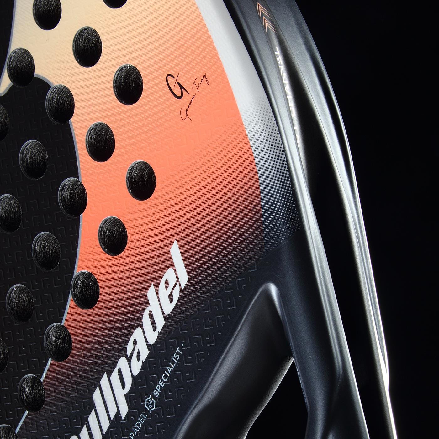 Close-up of the Bullpadel Elite W 2026 Padel Racket by Bullpadel, a lightweight racket featuring a black and orange gradient, circular holes, textured surface, and a visible signature on the upper right side.