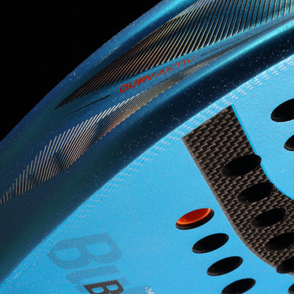 Close-up of the Bullpadel Vertex 05 W 2026 Padel Racket, featuring textured blue details, ventilation holes, a black carbon-patterned area, and "DURV AKTIV" in red on top—design inspired by Delfi Brea’s performance.