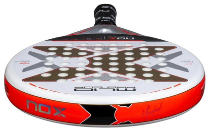 A close-up of the NOX ML10 Pro Cup Coorp By Miguel Lamperti 2025 padel racket shows its red, black, and white colors with a bold "X" design and multiple holes for better aerodynamics, inspired by pro player Miguel Lamperti.