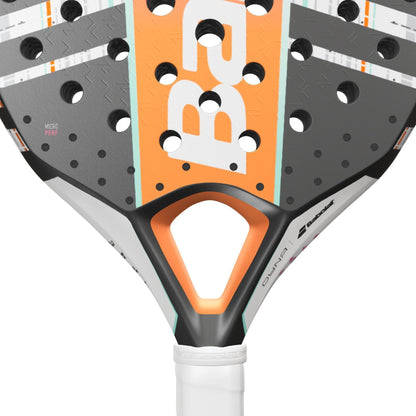 Close-up of the Babolat Dyna Energy Padel Racket, a lightweight women's model in orange, black, white, and gray with perforated holes, textured surface, and the Babolat logo by the handle.