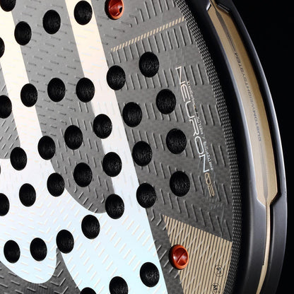 Close-up of the Bullpadel Neuron 02 2026 Padel Racket face shows its textured surface, circular holes, visible Bullpadel branding, and black and gold edge with the model name.