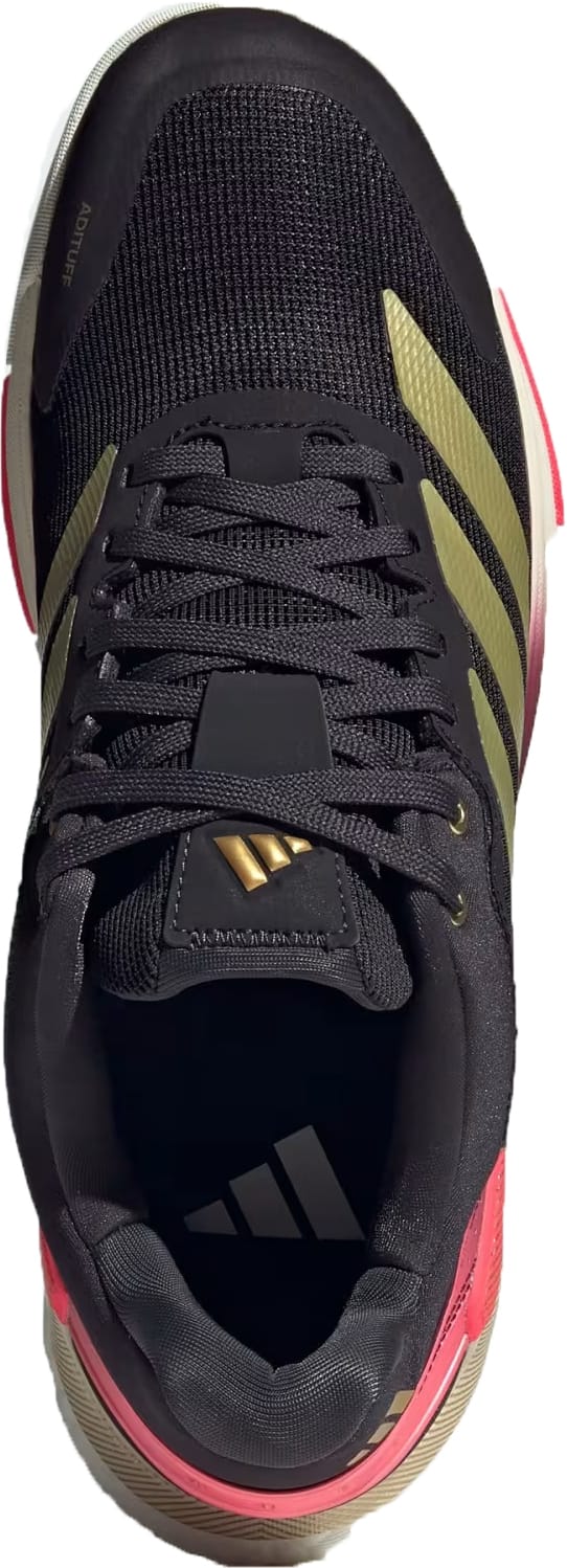 The adidas Crazyquick Boost Men's Padel Shoes in Core Black/Gold Metallic/Solar Turbo feature gold stripes, a gold tongue logo, and pink accents. These sneakers offer superior energy return with every step.