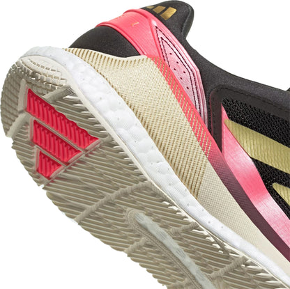Close-up of the heel and sole of adidas Crazyquick Boost Men's Padel Shoes in Core Black, Gold Metallic, and Solar Turbo, with mesh-like material and textured white outsole for optimal energy return.